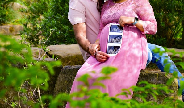 Expecting couple in London park holding ultrasound scan, showcasing maternal bond.